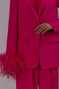 Detailed close-up of pink blazer sleeves with luxury ostrich feather cuffs and fine fabric texture