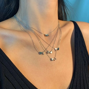 Layered S925 silver necklaces featuring heart and letter pendants on female model