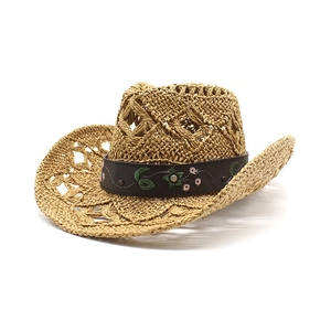 Detail of hand-woven straw cowboy hat featuring floral embroidery and metal studs
