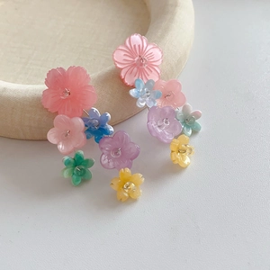 Macro detail of colorful resin flower dangle earrings with bohemian tassel style