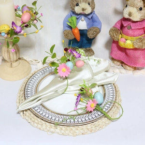 Detail of Easter napkin rings with daisies, colorful eggs, and green leaves on a table