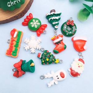 Flat lay of colorful 3D Christmas resin charms including trees and snowflakes on blue