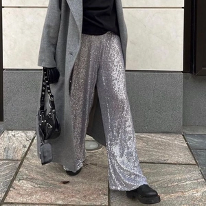 Detailed view of women's wide-leg trousers featuring shimmering silver sequins for parties
