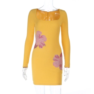 Dettaglio mini abito a costine giallo con ricami floreali in paillettes rosa vivaci