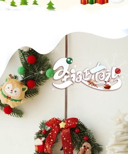 Christmas wreath detail with red berries, pine needles and plush holiday ornaments