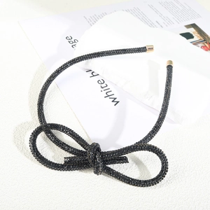 Close-up of sparkling black rhinestone bow headband with elegant gold metal end caps