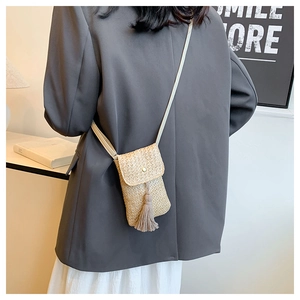 Fashionable straw crossbody bag with tassel detail styled with a casual chic outfit