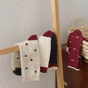 Detailed close-up of festive cotton knit socks with heart patterns and vintage textures