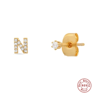 Detail of S925 sterling silver golden letter N earring with inlaid clear gemstone