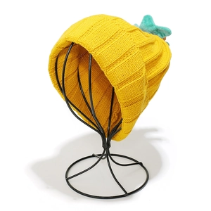Detailed knit texture of yellow pumpkin hat featuring blue star crochet decorations
