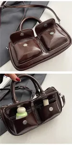 Detail of dark brown vintage Boston bag with glossy patent finish and double front pockets