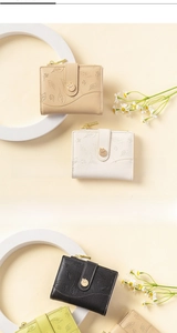 Detail view of colorful short wallets with leaf embossing and metal zipper closure
