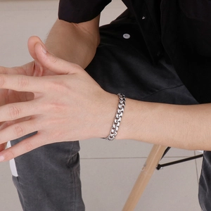 Close-up of hiphop stainless steel Cuban chain bracelet worn on male model wrist
