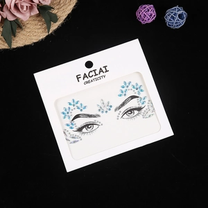 Detailed view of blue acrylic face jewels on card with makeup line art guide