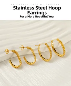 Detail of vintage twisted gold stainless steel earring set on white texture base