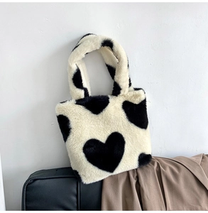 Close-up of black and white heart pattern plush tote bag with soft faux fur texture