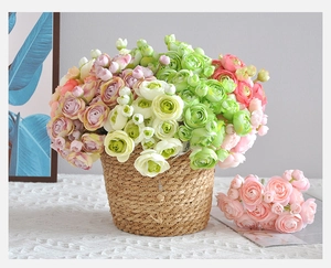 Detail of colorful artificial ranunculus flowers in a handmade woven grass basket