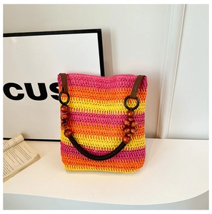 Close-up of rainbow gradient woven tote bag featuring brown wood-beaded handles