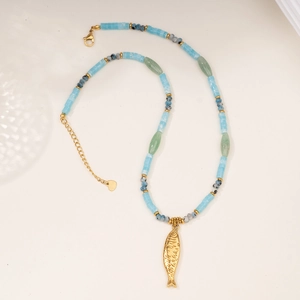 Detail of beaded necklace featuring natural stones, golden fish charm, and heart clasp