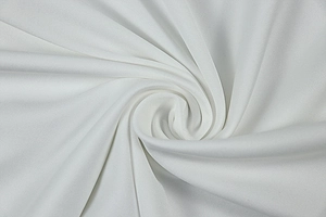 Close-up of white knitted fabric texture showing soft spiral drape and material quality