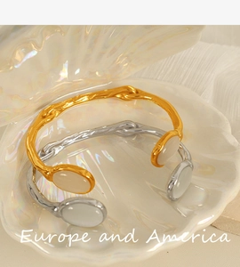 Detail of vintage irregular open cuff bangles with oval cat eye stones in gold and silver