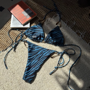 Detail of zebra print bikini top with gold metal rings and adjustable ties