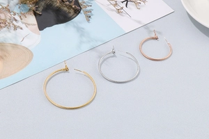 Detailansicht strukturierter Creolen in Gold, Silber und Roségold mit feiner Metalltextur