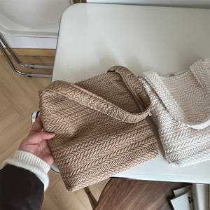 Close-up of woven shoulder bag showing rice spike texture in khaki and cream white tones