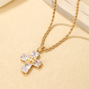 Golden bear cross necklace with zircons and rope chain on textured background