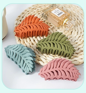 Macro detail of large leaf hair claws in matte orange, green, blue and pink morandi tones