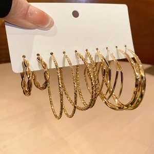 Set of six gold geometric hoop earrings with twisted and textured metal finishes