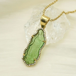 Detail of 18k gold plated Virgin Mary pendant with green glass and sparkling crystals