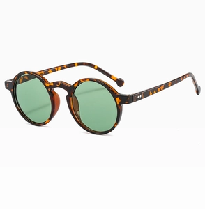 Detailweergave van een ronde tortoise zonnebril met groene glazen en metalen rivets