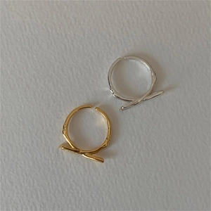 Detail of minimalist 925 sterling silver bow rings in gold and silver textured finish