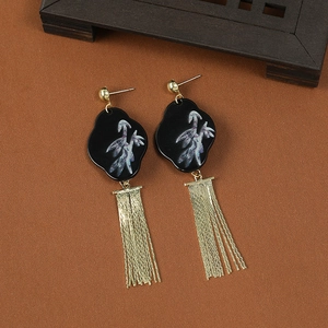 Detailed view of Chinese style gold tassel earrings with black cloud pattern pendants