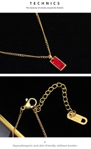 Detailed view of golden stainless steel necklace with a red rectangular gemstone pendant