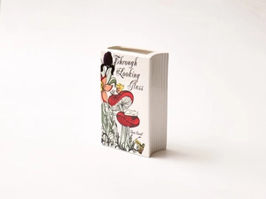 Detail of book-shaped ceramic vase featuring colorful Alice in Wonderland illustration