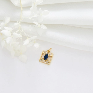 Detail eines goldenen quadratischen Anhängers mit blauem Edelstein und Zirkonia