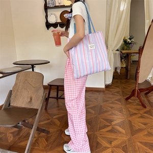 Dettaglio della borsa tote a righe blu e rosa con etichetta in tessuto in stile casual