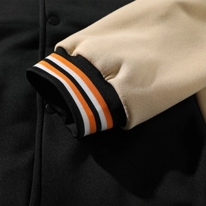 Close-up of color-block baseball jacket with striped ribbed cuffs and matte buttons