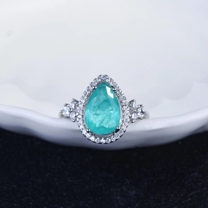 Luxury pear-cut turquoise stone ring with diamonds on a wave ceramic plate