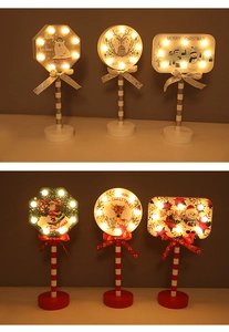 Detail of Christmas wooden LED lamps featuring festive patterns and red ribbon bows