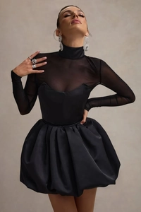 Détail d'une robe noire élégante avec empiècements en tulle et jupe plissée