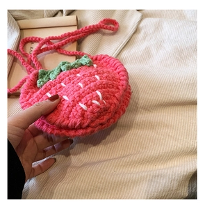 Detail einer handgefertigten rosa Erdbeer-Umhängetasche aus Strick mit grünen Blättern