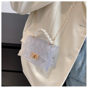 Detail of transparent PVC mini bag with faux pearl handle and gold chain strap
