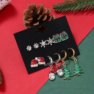 Festive Christmas earring set featuring snowflake, gift box, and tree designs on card