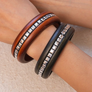 Détail de bracelets carrés en bois rétro avec des clous métalliques argentés