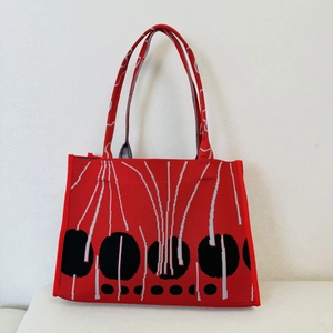 Close-up of red knitted tote bag with retro geometric circle and line patterns