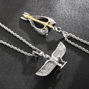 Macro shot of silver wheat chain with Egyptian goddess Isis and winged arrow pendants