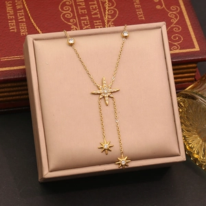 Detailed close-up of a gold starburst pendant necklace with zircons in a vintage gift box